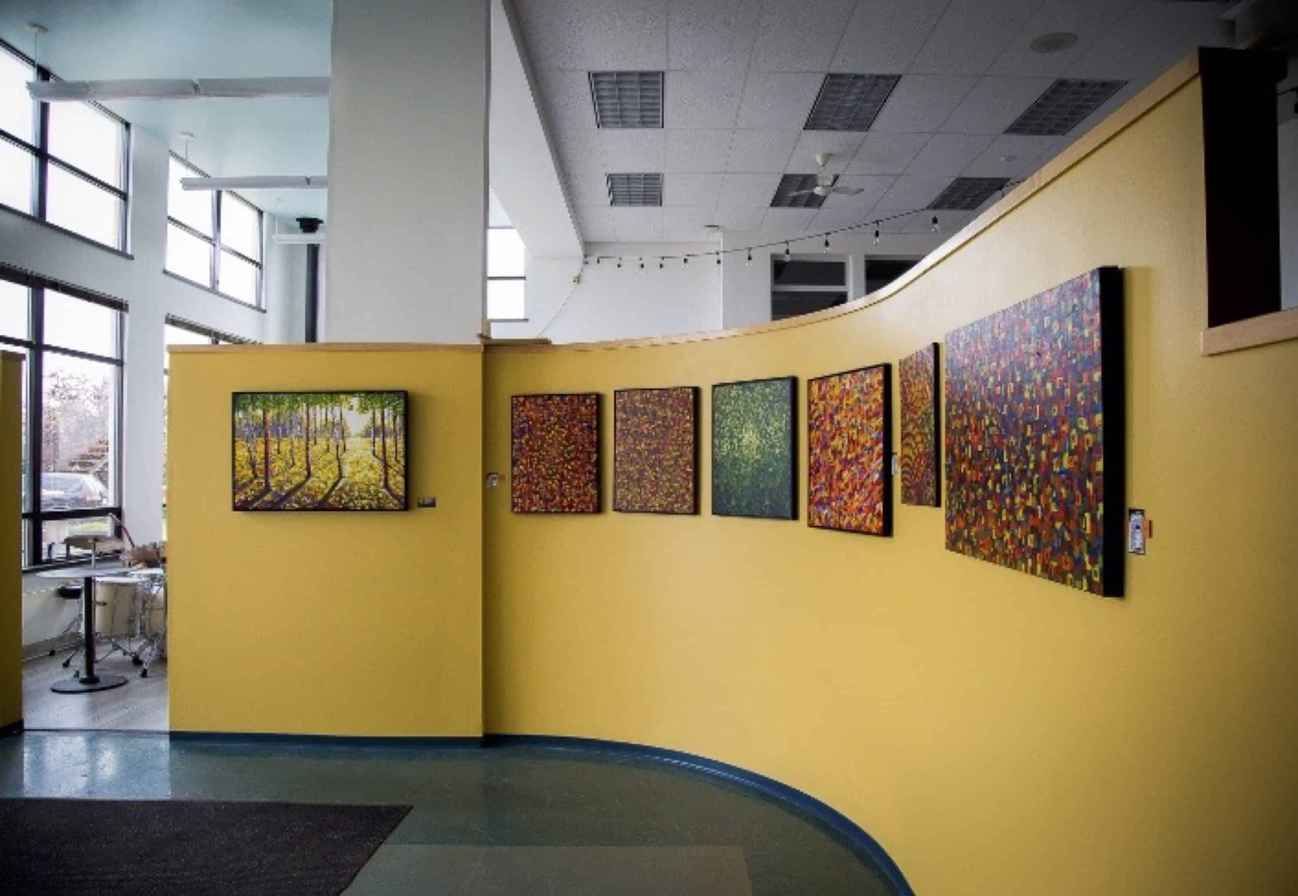 Photo of a curved yellow wall of art hanging on the wall. 

Another photo of the outside the McTavish Academy on a sunny day. 