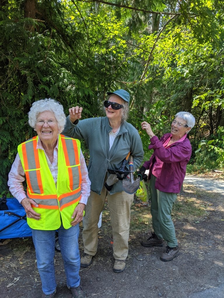 Picture of three women having fun and smiling out in the forest 